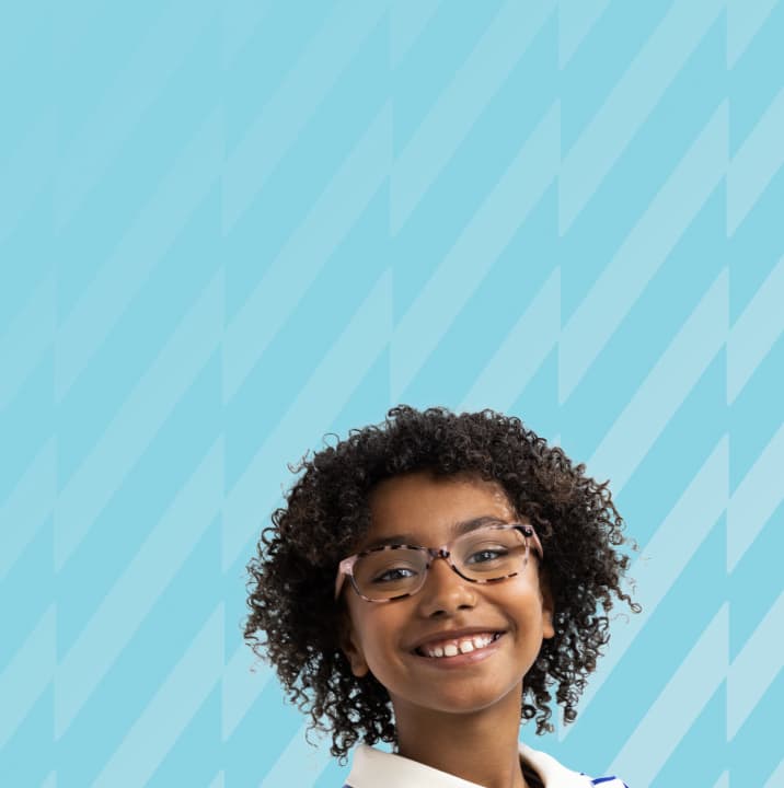 A girl with curly black hair wearing tortoiseshell glasses with Trivex lenses.
