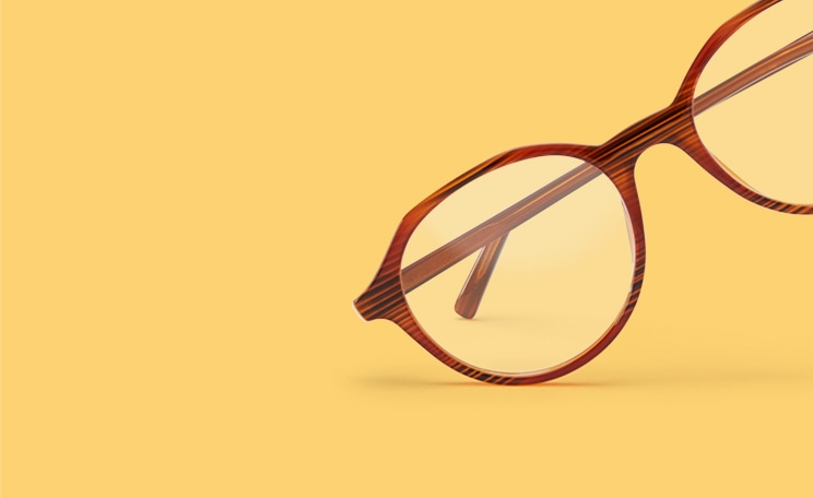 Zenni round glasses #2030715 in brown with subtle woodgrain pattern against a yellow background.