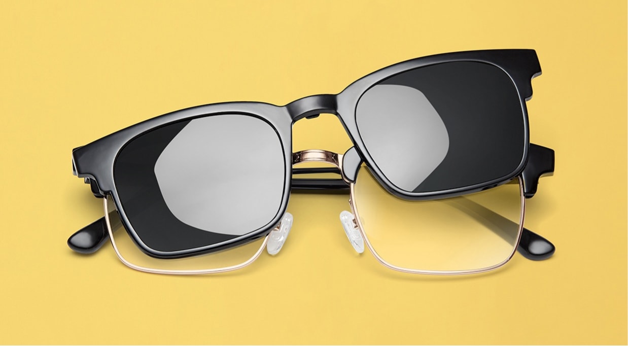 Black square glasses with orange interior shown with magnetic clip-on sunshade with dark tint.