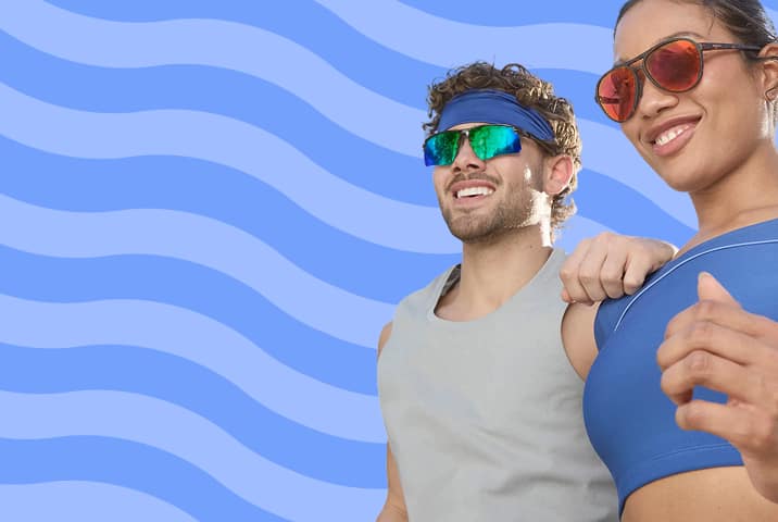 A man wearing wraparound style Zenni sports sunglasses and a woman wearing tortoiseshell aviator sunglasses. Blue wavy stripe background.