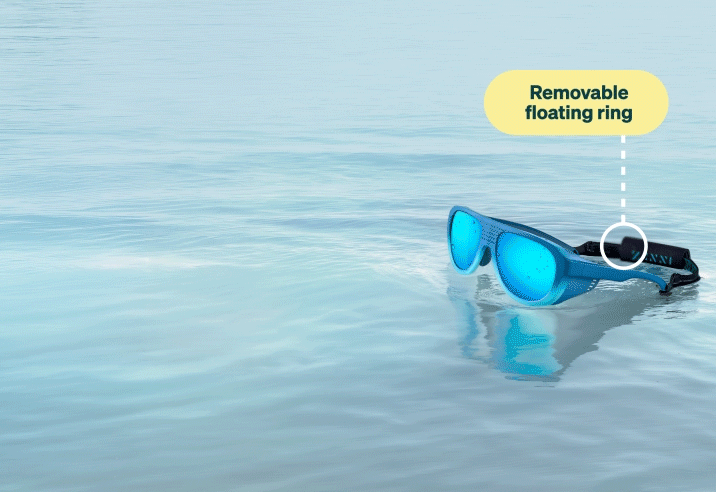 Blue water sports sunglasses with bright blue mirrored lenses floating in water, diagramming features including adjustable anti-slip nose pad, removable anti-fog side shields, anti-slip temple, and removable floating ring.