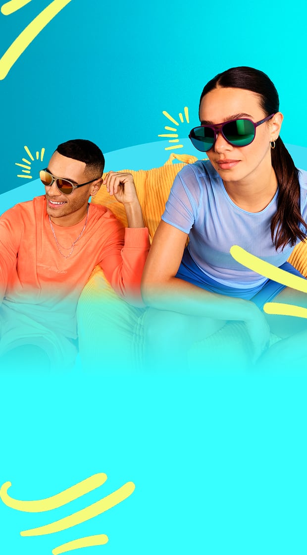 Man and woman smiling and posing in colorful sunglasses against a bright blue background.