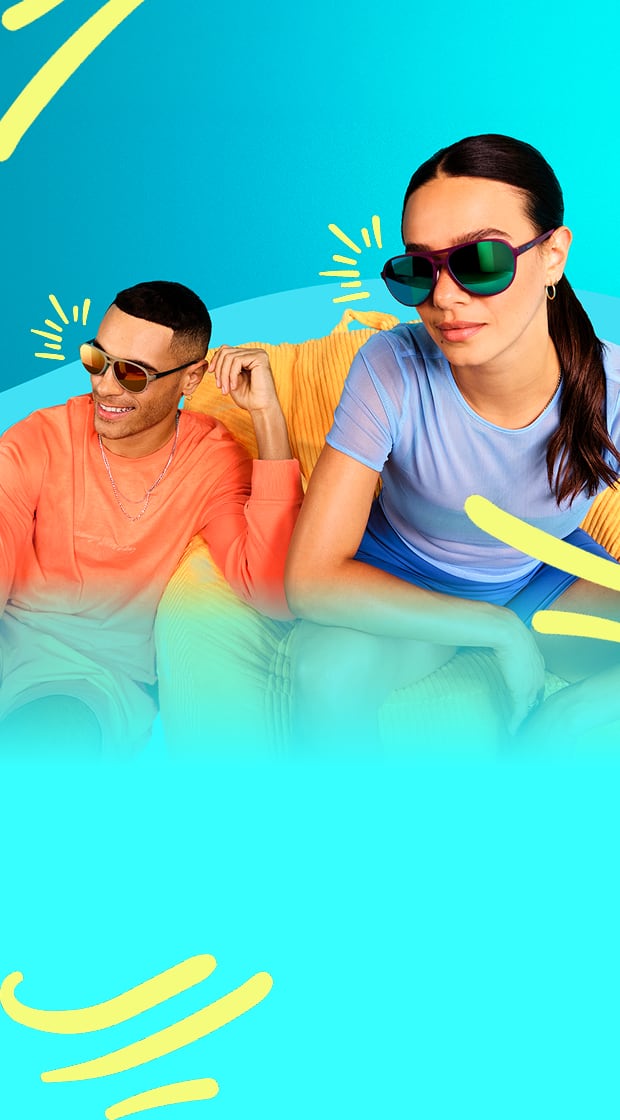 Man and woman smiling and posing in colorful sunglasses against a bright blue background.
