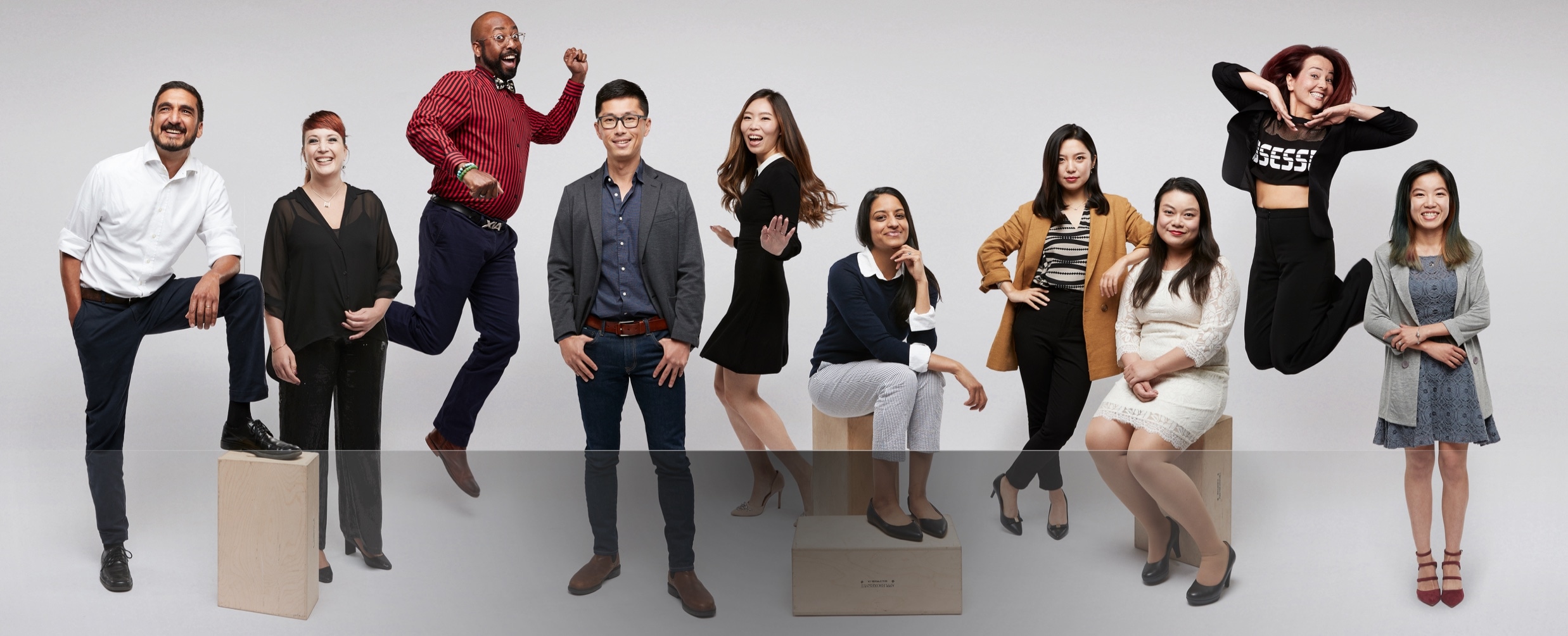 Exuberant Zenni employees striking poses against a white background.