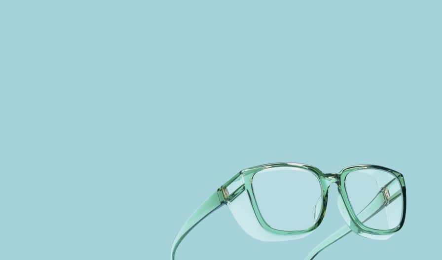 Lentes protectores de marcos transparente verde claro sobre fondo azul claro.