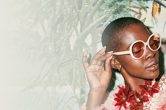 A Black women rocking iconic patterned round sunglasses.