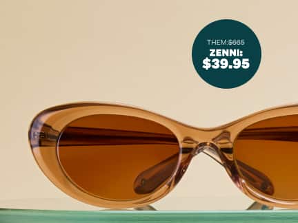 Brown transparent cat-eye sunglasses with brown lenses, sitting on a glass shelf on a beige background. 