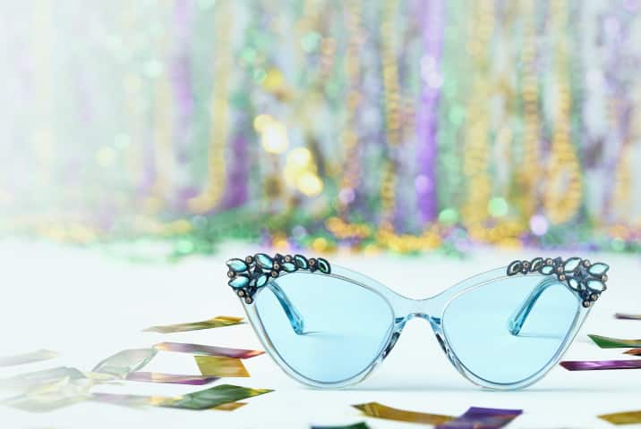 Light blue cat-eye Zenni sunglasses with jeweled corners on festive confetti background.