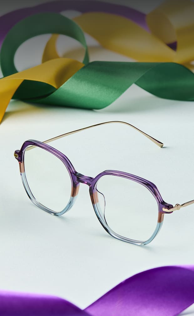 Purple and blue translucent geometric Zenni glasses with gold temples on white background with ribbons.