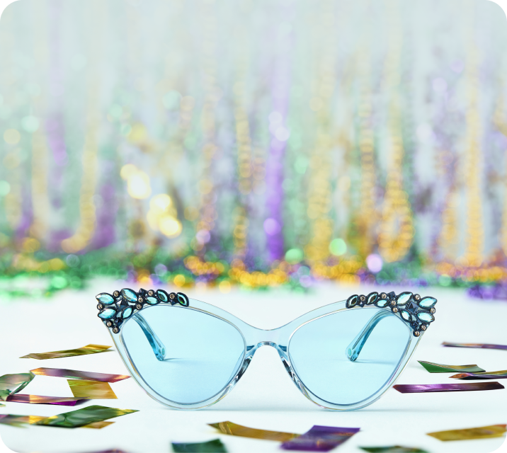 Light blue cat-eye Zenni sunglasses with jeweled corners on festive confetti background.