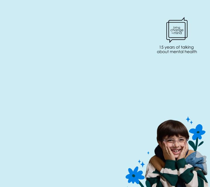 A child in striped sweater and a red-haired adult in glasses smile together against a light blue background with flower illustrations. The Bring Change to Mind logo appears with the words ‘15 years of talking about mental health’.