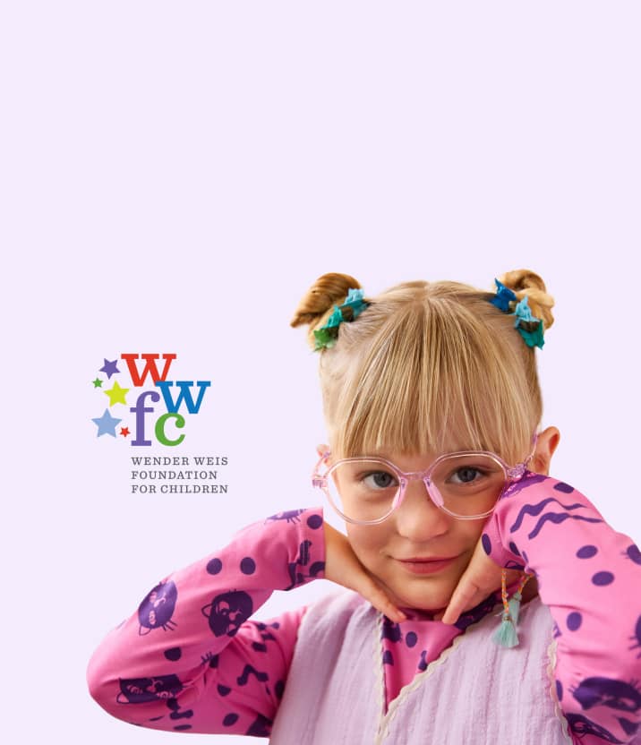 A young child with blonde hair in two decorated buns smiles while resting their chin on their hands, wearing pink glasses and a colorful outfit against a pale lavender background. Purple stars surround them, and the Wender Weis Foundation for Children logo appears in the upper right corner.