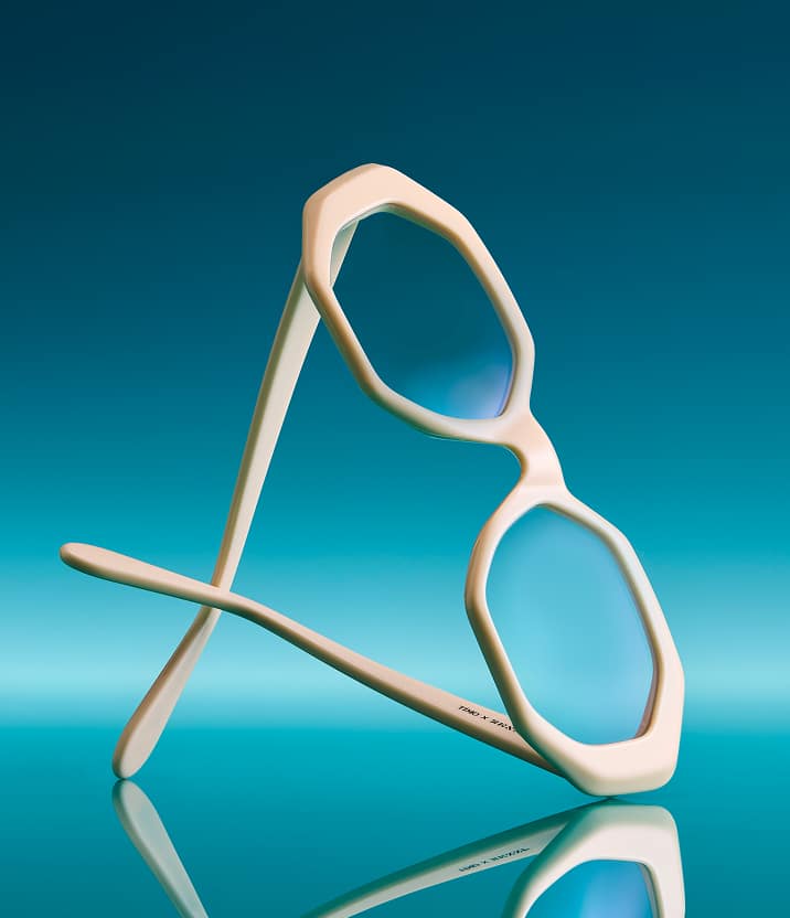 A close-up artistic photo of the Breezy frame from the Timo x Zenni collection against a deep blue background.