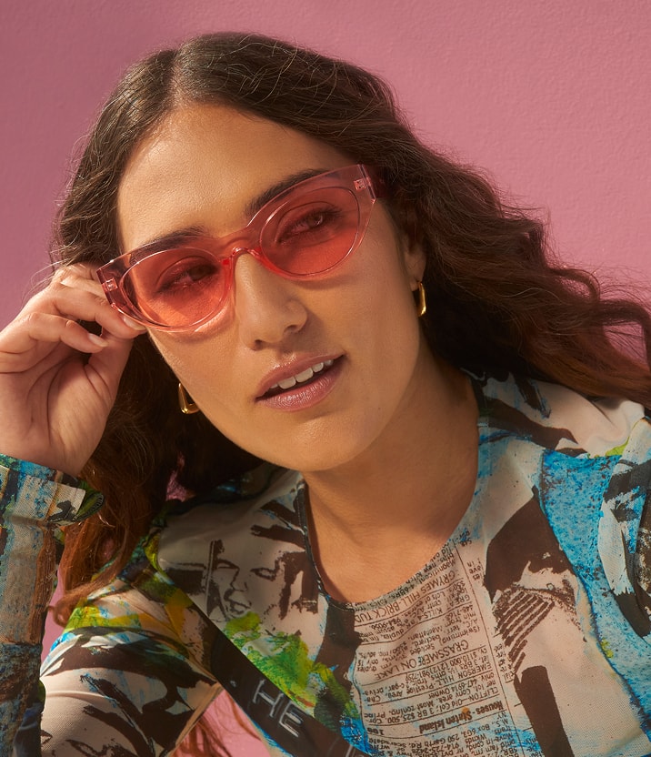 Close-up of a woman wearing an abstract, graffiti-inspired style top.