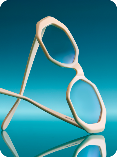 A close-up artistic photo of the Breezy frame from the Timo x Zenni collection against a deep blue background.
