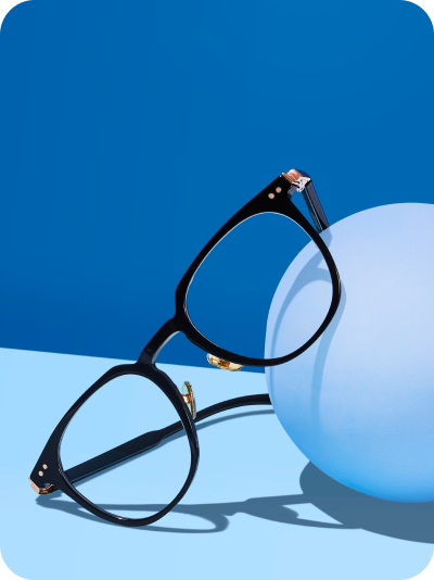 A product photo of Zenni black round glasses on a medium and light blue background, casting a shadow.