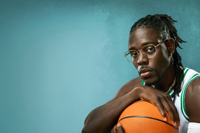 Jrue Holiday in Zenni 'Hendrix' glasses, wearing a basketball jersey and holding a basketball, against a teal background.