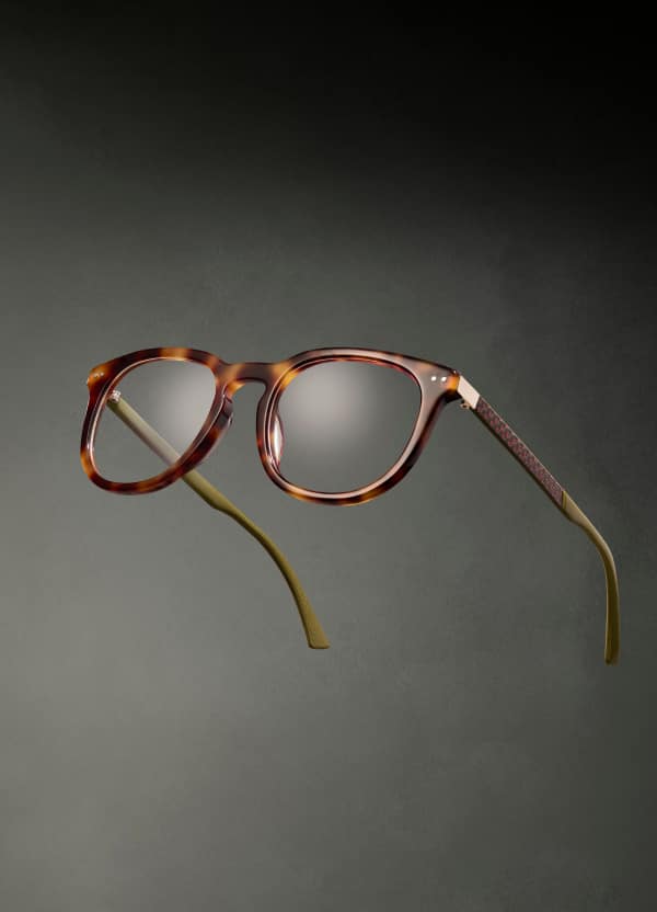 Round tortoiseshell optical eyeglasses “Crossover” from the Jrue Holiday x Zenni eyewear collection are shown hovering in front of a gray background.