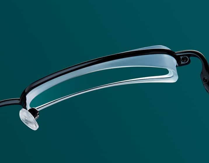 A thick Basic 1.50 index lens in a black metal frame viewed from above.