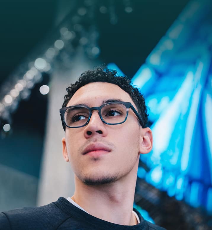Man wearing Zenni blue rectangular glasses in a brightly lit indoor setting