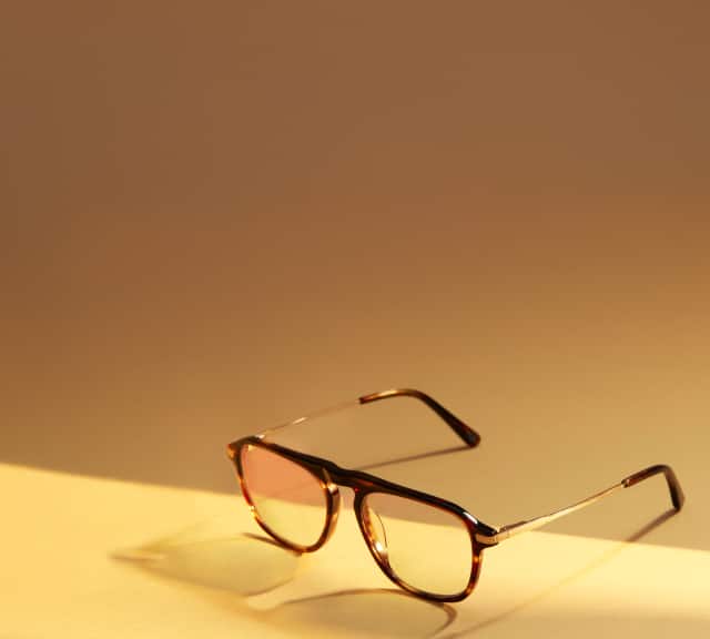 Close-up of Zenni Chase Stokes collection glasses on a sunlit surface featuring tortoiseshell frames.