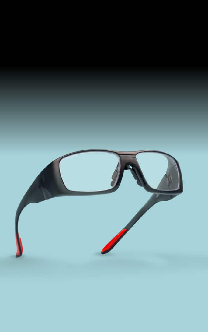 A pair of Zenni safety glasses with a red and black frame, accompanied by text promoting their protective features for work or DIY projects.