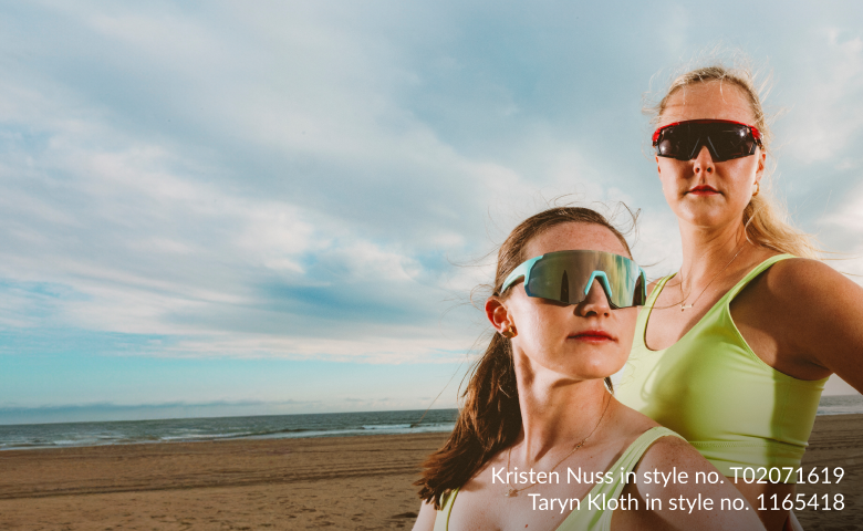 USA Volleyball Champions Kristen Nuss and Taryn Kloth wear performance-driven sports sunglasses against a sky backdrop. Taryn wears red sunglasses with a sleek frame and poses confidently, while Kristen wears teal, stylish sports sunglasses with a focus on protection. The text on the left side of the image reads "Sports Sunglasses" followed by "Performance-driven, 100% UVA/UVB protected sunglasses." The names and styles of the athletes are listed at the bottom right in small text.