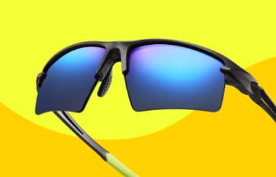 Black Zunnies sunglasses with blue mirrored lenses, shown in close-up against a two-toned yellow background.