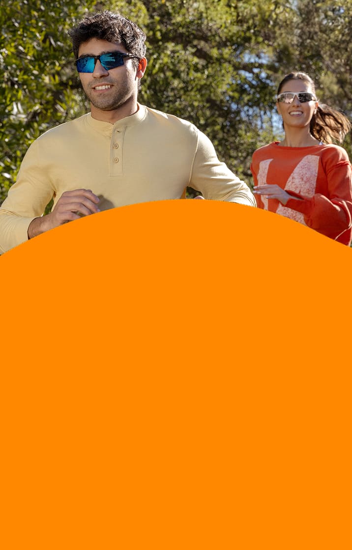 Two people jogging outdoors wearing Zunnies Sports Sunglasses under bright, sunny skies.