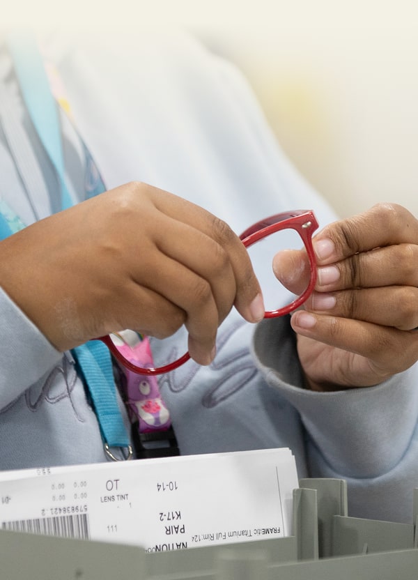 Hands adjusting red Zenni eyeglass frames