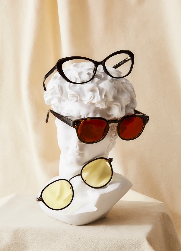 Three different Zenni eyeglass styles displayed on a white bust sculpture.