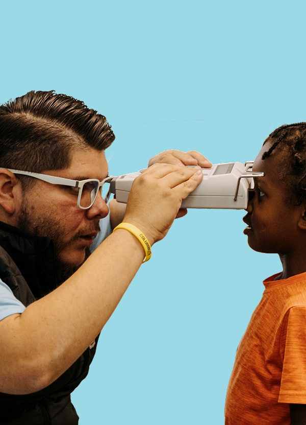 Healthcare provider conducting a vision screening exam on a child.