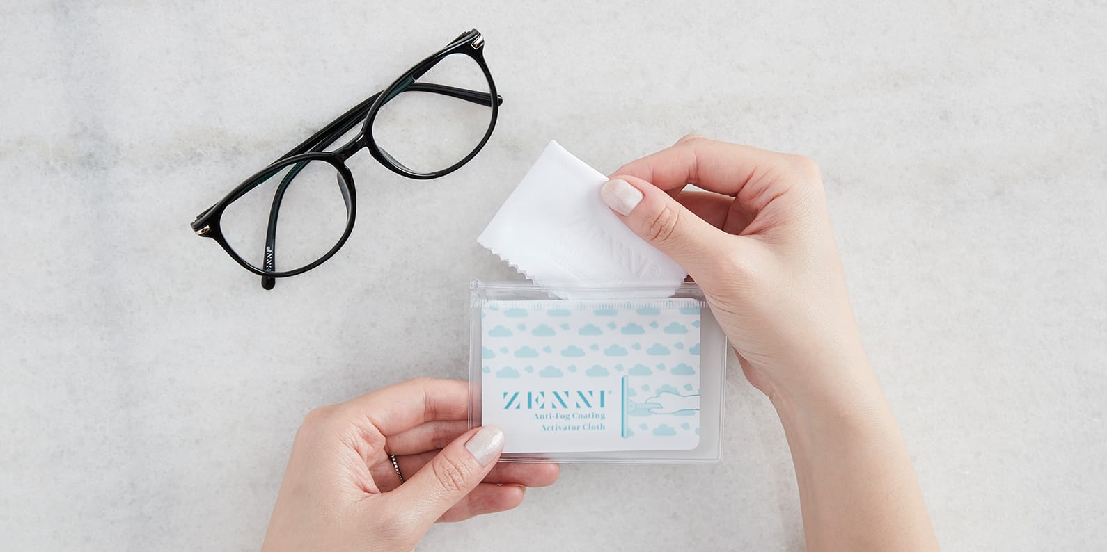 Image of a pair of Zenni glasses and the person putting the Zenni's Anti-fog Activator Cloth back to the original, resealable pouch.
