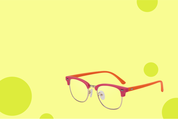Red browline kids’ glasses on a beige background with green circles.