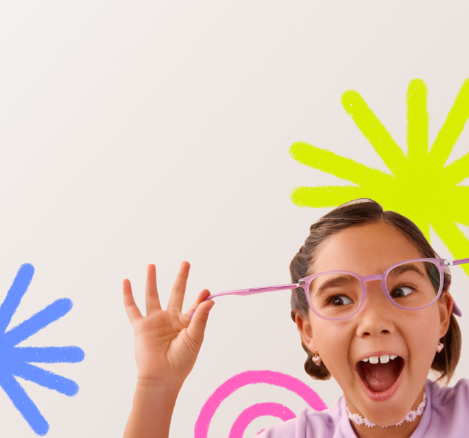 Close-up of an excited young girl with an open-mouthed expression, playfully pulling back the flexible temple arm of her purple round eyeglasses, set against a white background decorated with colorful doodles.