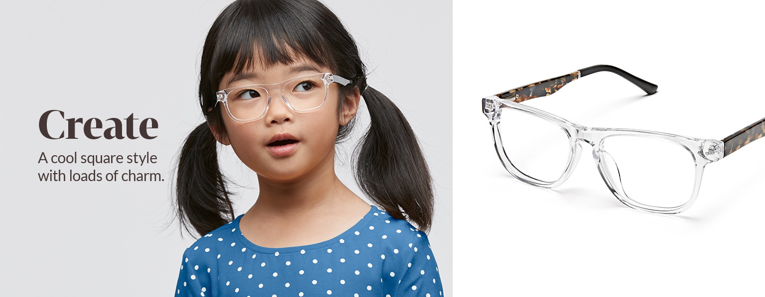 Young girl with dark brown hair in pigtails wears clear Create square glasses #4441123 and a blue shirt with white polka dots.