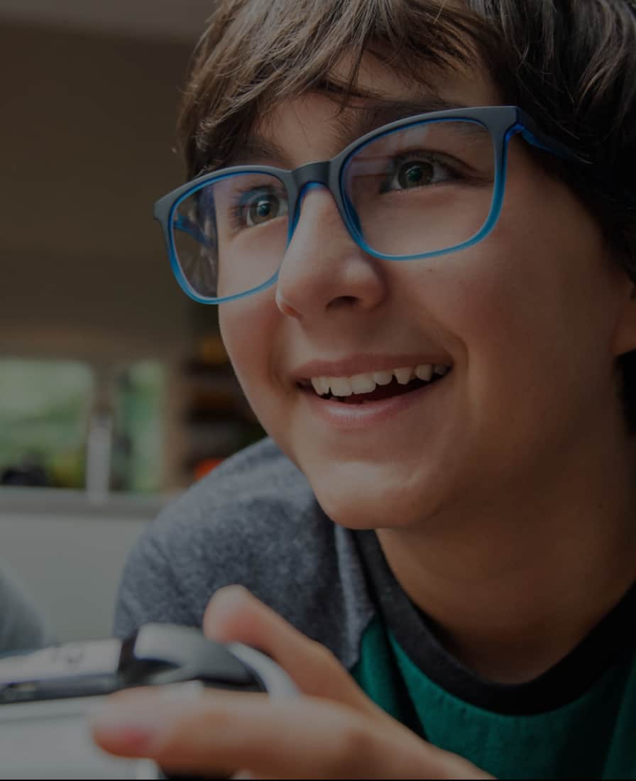 Two teenagers are wearing green round and blue square Blokz blue light glasses to protect their eyes from gaming.