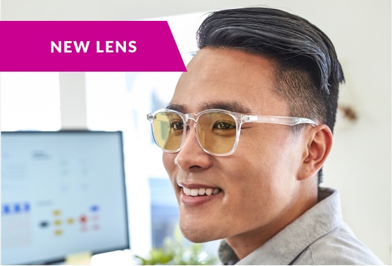 Image of a man wearing Zenni glasses with blokz anti-fatigue lenses in them, in an office setting with a note that says ‘new lens’. 