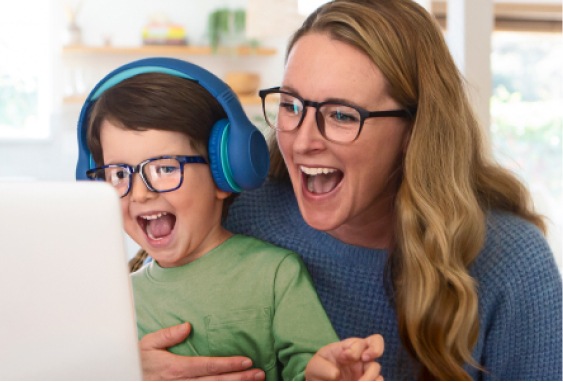 Image of a mom and kid enjoying themselves together in front of a laptop, both wearing Zenni glasses with blokz lenses. 