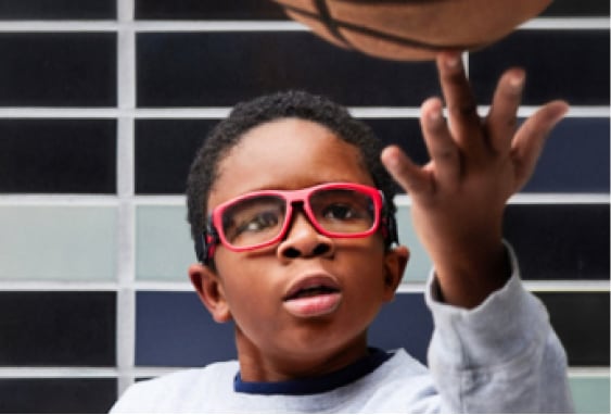 Image of a kid playing basketball, wearing Zenni protective sports goggles with impact-resistant trivex lenses.