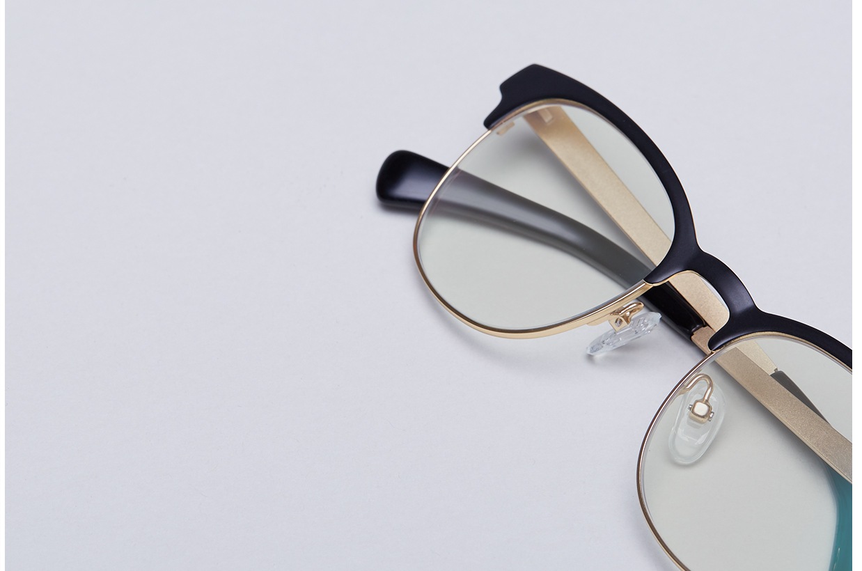 Black browline glasses with gold temple arms and Blokz blue blocker lenses.