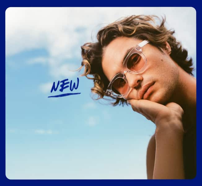 Chase Stokes wears Zenni frames with EyeQLenz featuring Zenni ID Guard lenses, posing outdoors under a bright sky with the word 'NEW' beside him.