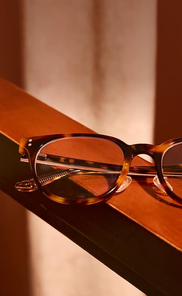 Tortoiseshell round Zenni glasses on a wood surface.