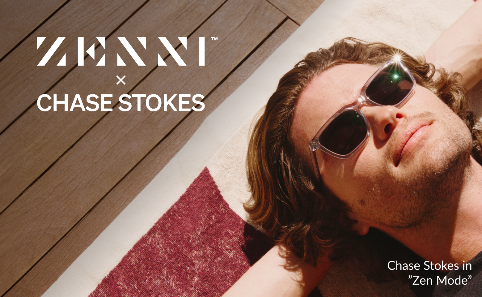 Chase Stokes lying on his back in the sun, sporting wavy brown hair and Zenni Zen Mode sunglasses, on a wooden deck.