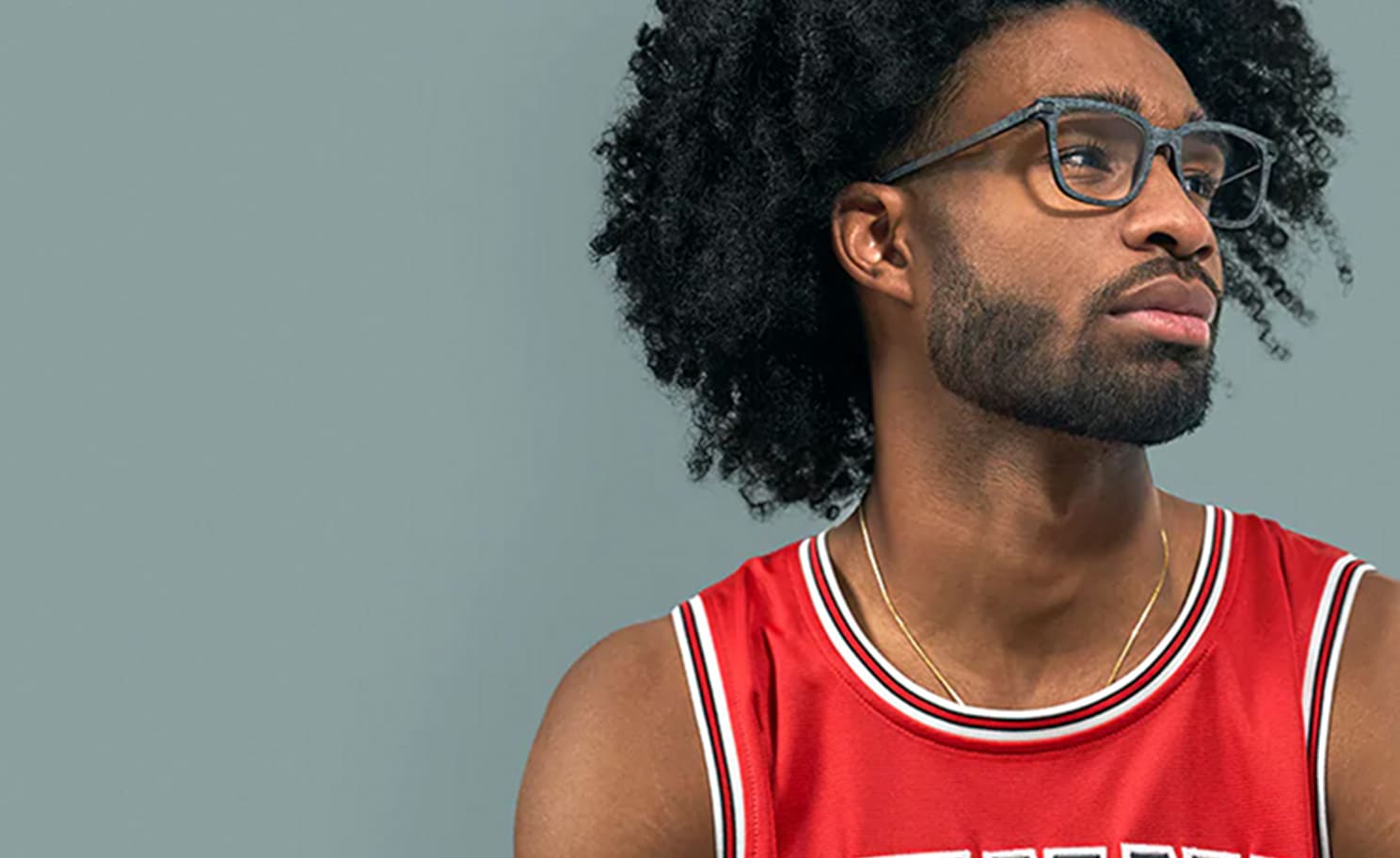 Coby White in a red Zenni basketball jersey, wearing Zenni square glasses #2026616, against a gray background.