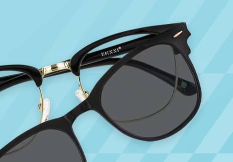 A close-up of black clip-on sunglasses with dark lenses and gold accents is shown against a blue geometric background.