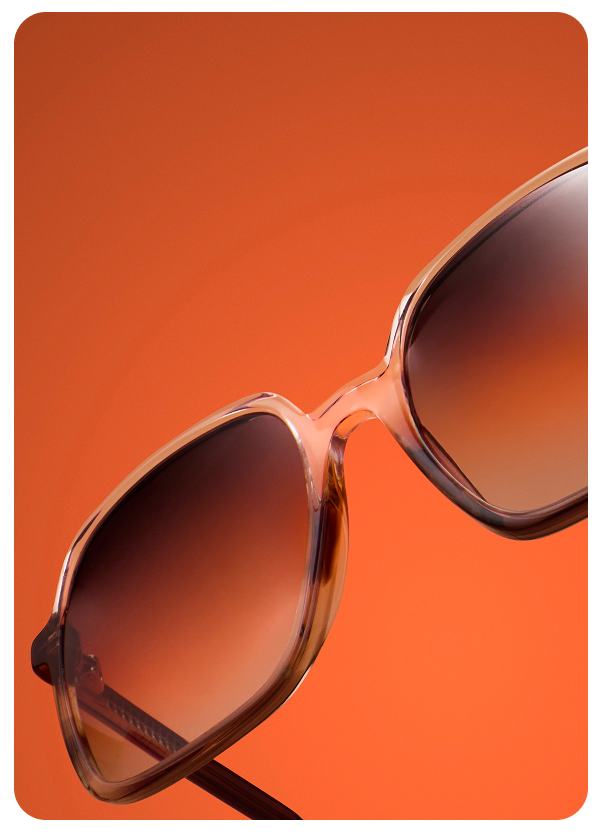 Zenni oversized gradient-lens sunglasses in translucent tan against an orange backdrop.