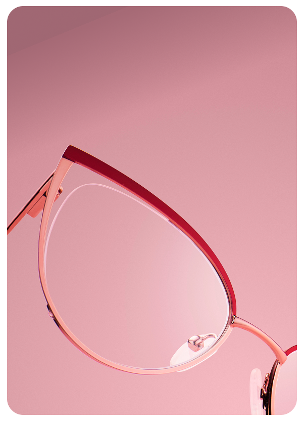 Close-up of Zenni cat-eye pink metal glasses with red trim, set against a pink backdrop.