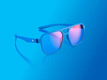 A pair of bright blue sunglasses with pink-tinted reflective lenses is displayed against a smooth blue gradient background.