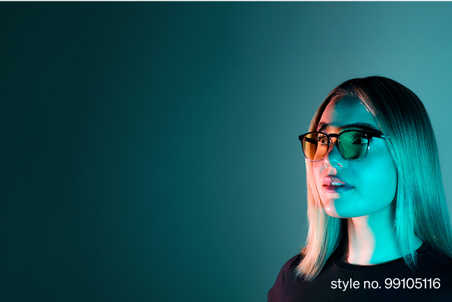 A woman with straight blonde hair wears stylish yellow-lensed round glasses style no. 99105116 under moody teal and orange lighting.